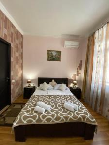 a bedroom with a large bed with two night stands at Guest house Lusia in Tbilisi City