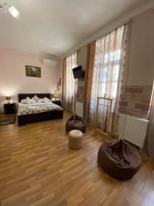 a bedroom with a bed and two ottomans at Guest house Lusia in Tbilisi City