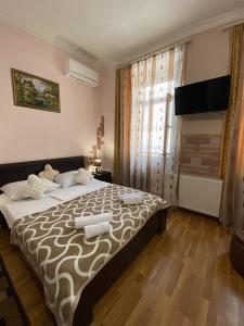 a bedroom with a large bed and a large window at Guest house Lusia in Tbilisi City