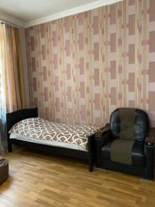 a bedroom with a bed and a chair at Guest house Lusia in Tbilisi City