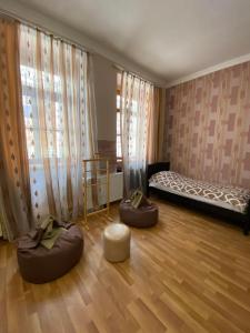 a room with two ottomans and a bed in a room at Guest house Lusia in Tbilisi City