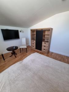 a living room with a flat screen tv and a chair at kleines Apartment in Wittenburg