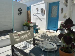una mesa con copas de vino y una puerta azul en Brinia Cosy Apartment, en Poros