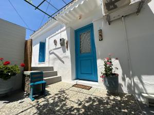 una puerta azul en el lado de una casa blanca en Brinia Cosy Apartment, en Poros