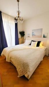 a bedroom with a large bed and a chandelier at Blu Apartment in Historical Hunbury in Bordighera