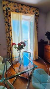 a living room with a glass table and a window at Blu Apartment in Historical Hunbury in Bordighera