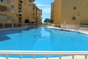 una grande piscina di fronte a due edifici di Estudio Rincon de la Victoria ( Malaga) a Rincón de la Victoria