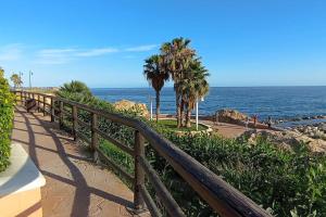 林孔德拉維克托里亞的住宿－Estudio Rincon de la Victoria ( Malaga)，海边的木人行道,种有棕榈树