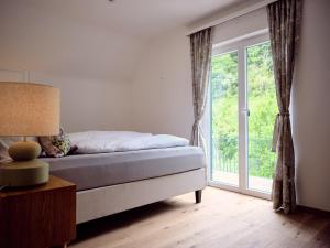 a bedroom with a bed and a large window at Top Ferienhaus bei Spitz / Wachau in Schwallenbach