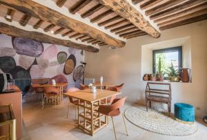 un comedor con mesas y sillas y un mural en Brotes Appartamento Ciliegio, en Sovicille