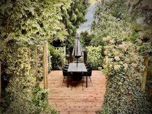- une table avec des chaises et un parasol dans le jardin dans l'établissement Mill House Townhouse, à Newmarket