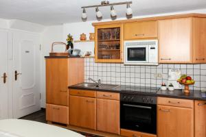 a kitchen with wooden cabinets and a microwave at Ferienwohnung am Sachsenring 