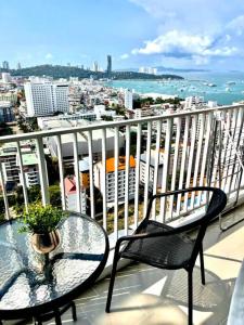 d'une table et de chaises sur un balcon avec vue sur la ville. dans l'établissement BASE Central PATTAYA Long Balcony with Infinity Pool & Free Netflix!, à Pattaya
