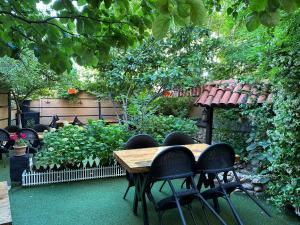 un patio con mesa y sillas y un jardín en Line Suite Hotel, en Kırklareli