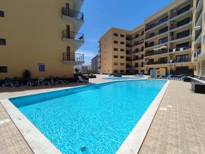 a swimming pool in the courtyard of a apartment building at 4B Alto dos Navegantes - Casas & Papéis in Armação de Pêra