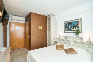 ein Schlafzimmer mit einem weißen Bett in einem Zimmer in der Unterkunft Beach House Sveti Jakov 1 in Dubrovnik