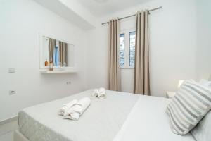 biała sypialnia z białymi ręcznikami na łóżku w obiekcie Overview Mykonos Apartments w mieście Mykonos