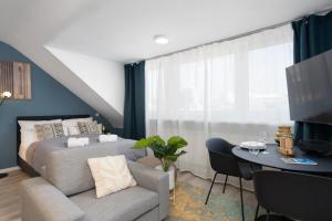 een slaapkamer met een bed, een bank en een tafel bij Arbio I Central Apartments Koblenz in Koblenz