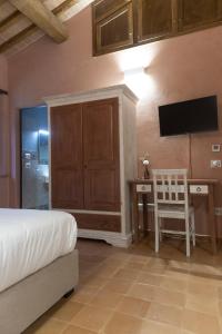- une chambre avec un lit et un bureau avec une télévision dans l'établissement MulinoNera, à Montefranco