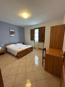 een slaapkamer met een bed en een bureau in een kamer bij Residence San Francesco in Pomarance