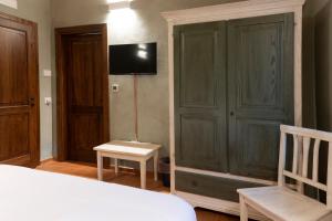 - une chambre avec un lit et une télévision murale dans l'établissement MulinoNera, à Montefranco
