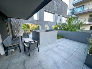 a patio with chairs and tables on a building at Apartament VIP Wola in Warsaw