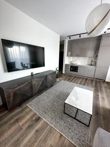 a living room with a large television and a table at Apartament VIP Wola in Warsaw +13 photos