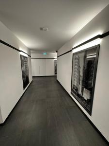an empty hallway with paintings of buildings on the walls at Apartament VIP Wola in Warsaw