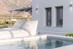 a bed sitting on a patio next to a swimming pool at MelivOia house collection in Foinikiá