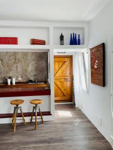 eine Küche mit zwei Hockern, einer Theke und einer Tür in der Unterkunft Casa Pura Vida y el Mar in Caleta de Caballo