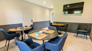 une salle à manger avec deux tables et des chaises dans l'établissement Le Clos des écureuils - chambres d'hôtes, à Sainte-Marie-la-Blanche