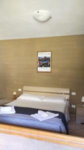 um quarto com uma cama grande e toalhas em Residence San Francesco em Pomarance