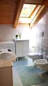 La salle de bains est pourvue de 2 lavabos, de toilettes et d'une fenêtre. dans l'établissement Villa Meledrio, à Dimaro