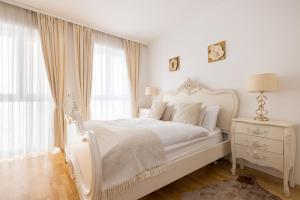 a white bedroom with a white bed and a window at Pfamhaus Penthouse in St. Wolfgang