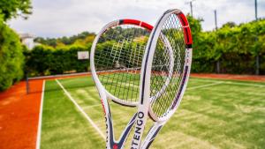 a tennis racket is standing on a tennis court at Club Beyy Resort Hotel - Ultra All Inclusive in Izmir