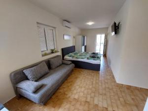 a living room with a couch and a bed at Studio apartment Aren in Porat