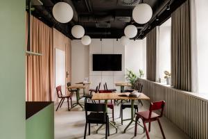 a restaurant with tables and chairs and a flat screen tv at PLANTONIA Aparthotel in Kraków