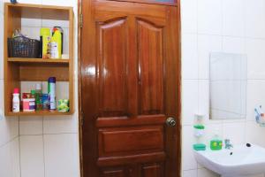 a bathroom with a wooden door and a sink at Artistic Oasis 2Bedrm Apartment in Buwate