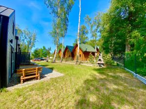 a park with a bench and a swing at Domy nad morzem- Family Resort - Chata Pirata 2 in Dziwnów