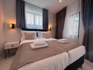 a bedroom with a large bed with two towels on it at Azalea Dalmacija Luxury Rooms and Apartments in Primošten
