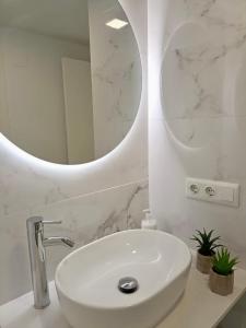 Baño blanco con lavabo y espejo en NUEVO !!! Apartamento Peñíscola Playa con piscinas y tenis, en Peñíscola