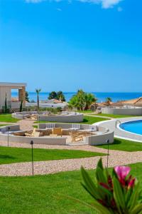 vista su un resort con piscina e oceano di Ajul Luxury Hotel & Spa Resort, a Registry Collection Hotel ad Ayía Paraskeví