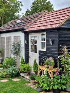 a black and white shed with a white door at Owl Lodge in Newport Pagnell