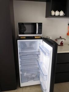 una nevera abierta en una cocina con microondas en Condo with great view in PJ, en Petaling Jaya
