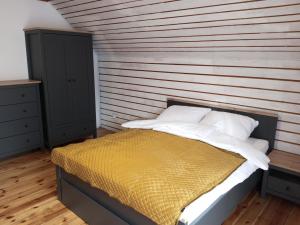 - une chambre avec un lit et un mur en bois dans l'établissement Apartament w Podgórzynie, à Podgórzyn