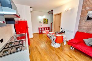 cocina y sala de estar con sofá rojo y mesa en Affittimoderni Bergamo Metro BGCO07, en Bérgamo