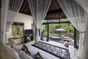 ein Schlafzimmer mit großem Bett und Badewanne in der Unterkunft The Kayon Valley Resort in Ubud