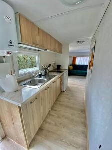 a kitchen with a sink and a refrigerator at Domek z widokiem na las in Nielisz