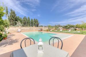 una piscina con tavolo e sedie in un cortile di Dependance con piscina a Taurisano