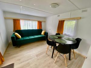 Domek z widokiem na las في Nielisz: غرفة معيشة مع أريكة خضراء وطاولة